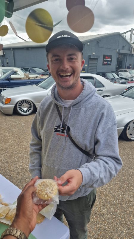 Smiling man buying a Cookie Chop cake.